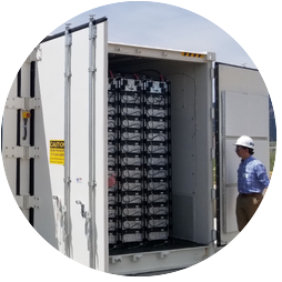 Worker showing insides of energy storage container