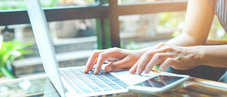 User searching on the internet. Close up on fingers and keyboard.