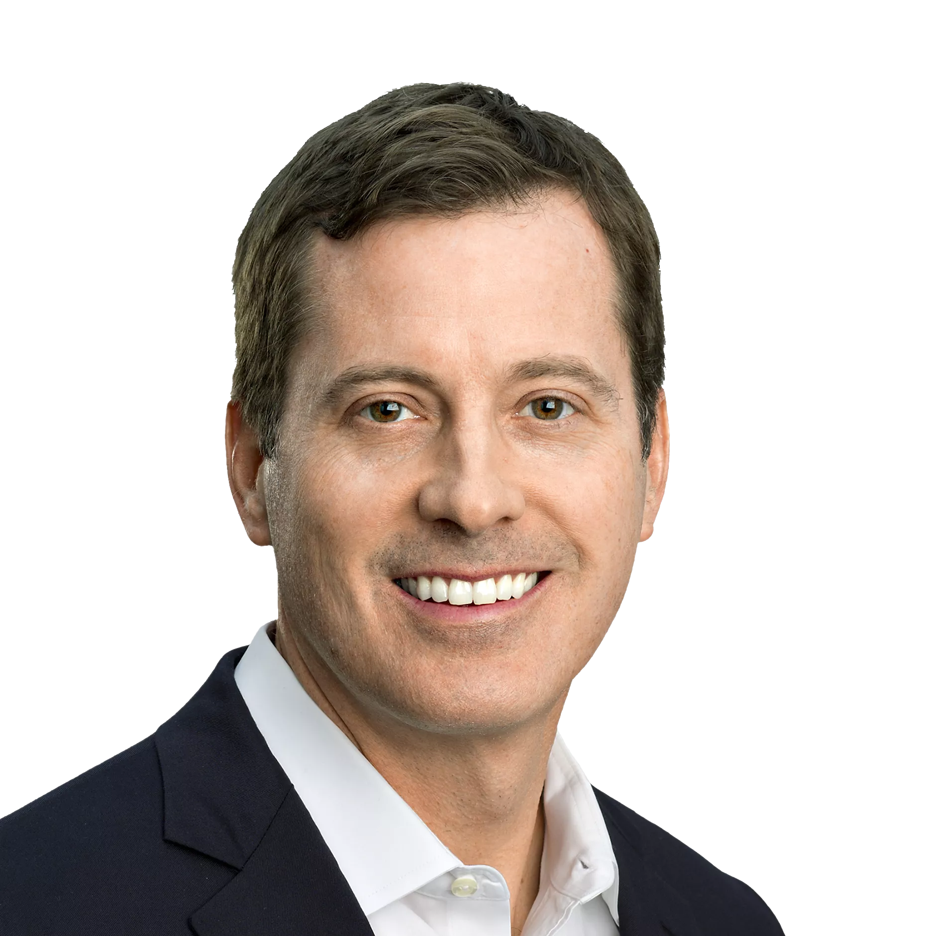 A man with short brown hair, wearing a dark suit jacket and white shirt, smiles at the camera against a plain white background.